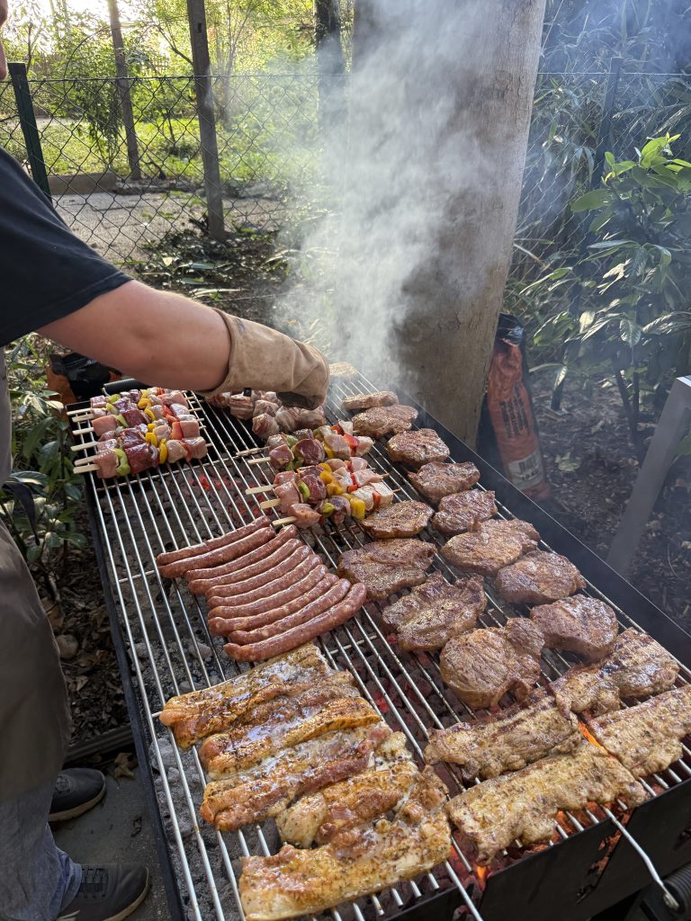 Griller voller Fleisch und Würste.